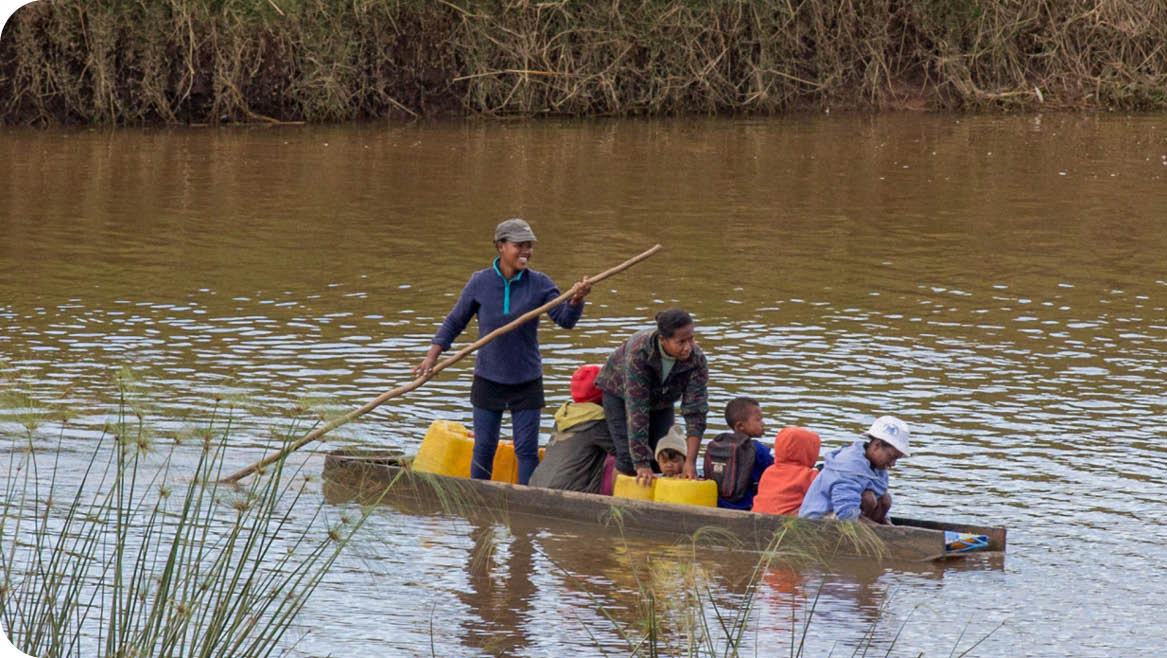 Mothers taking there children to school in a boat with cans to get drinking water 